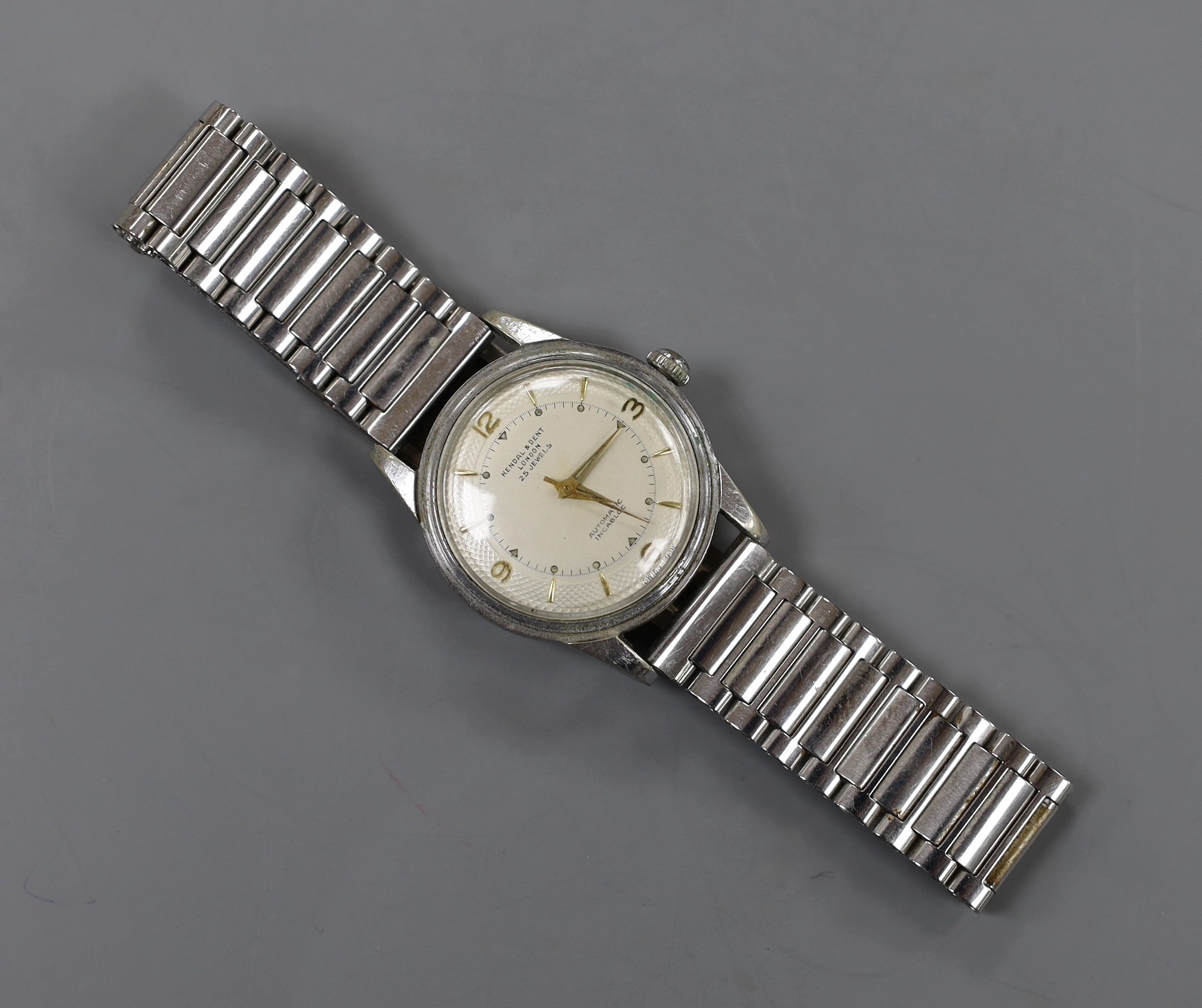A gentleman's stainless steel backed Kendall and Dent Automatic Incabloc wrist watch, on associated steel bracelet.